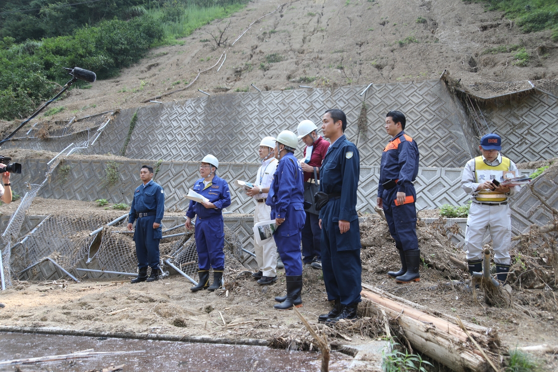 手前は浄水場の天日乾燥床、山からの土砂でフェンスが崩れている