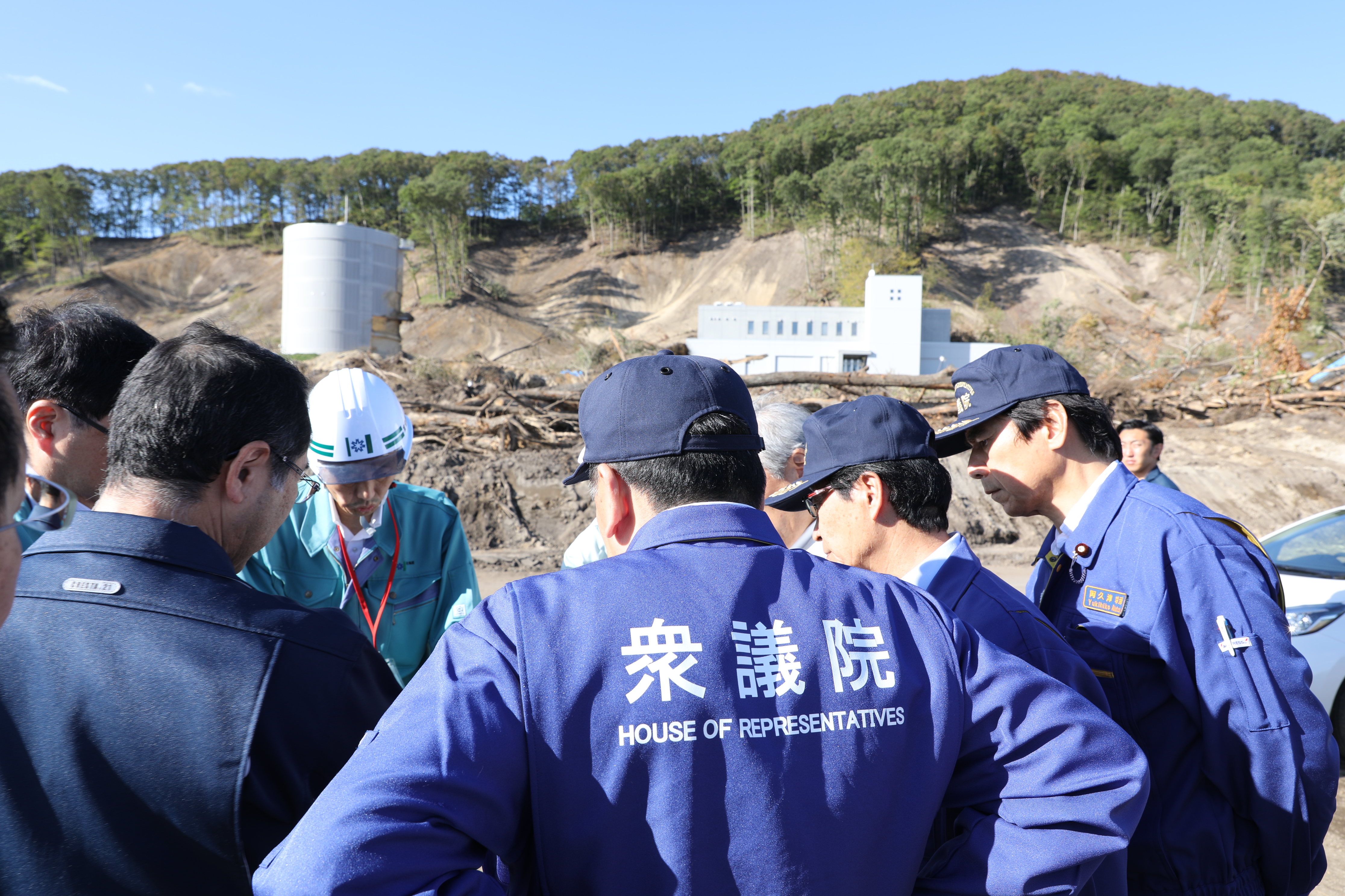 富里浄水場の前で説明を受ける枝野代表ら